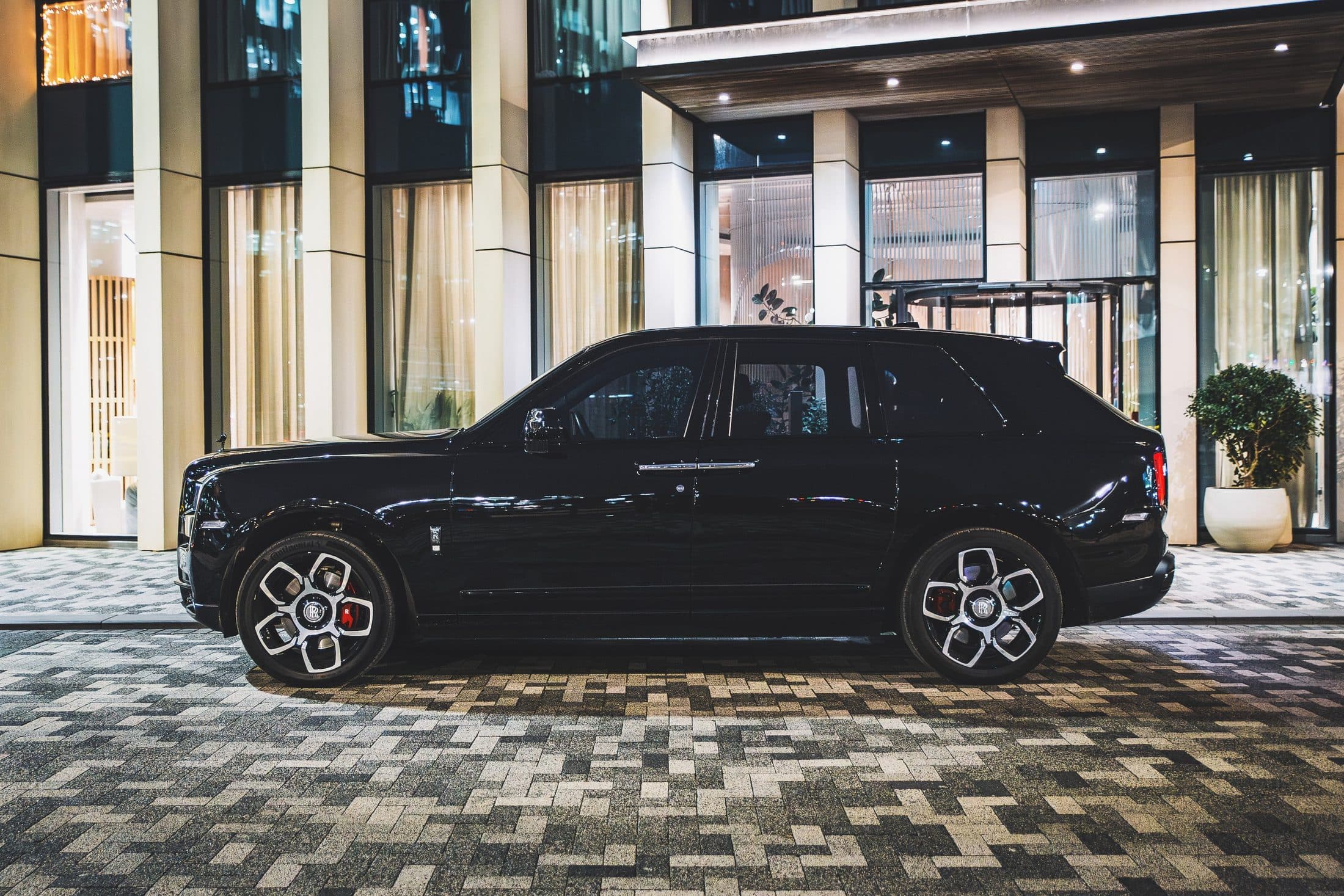 Rolls-Royce Cullinan waiting on a lit hotel forecourt