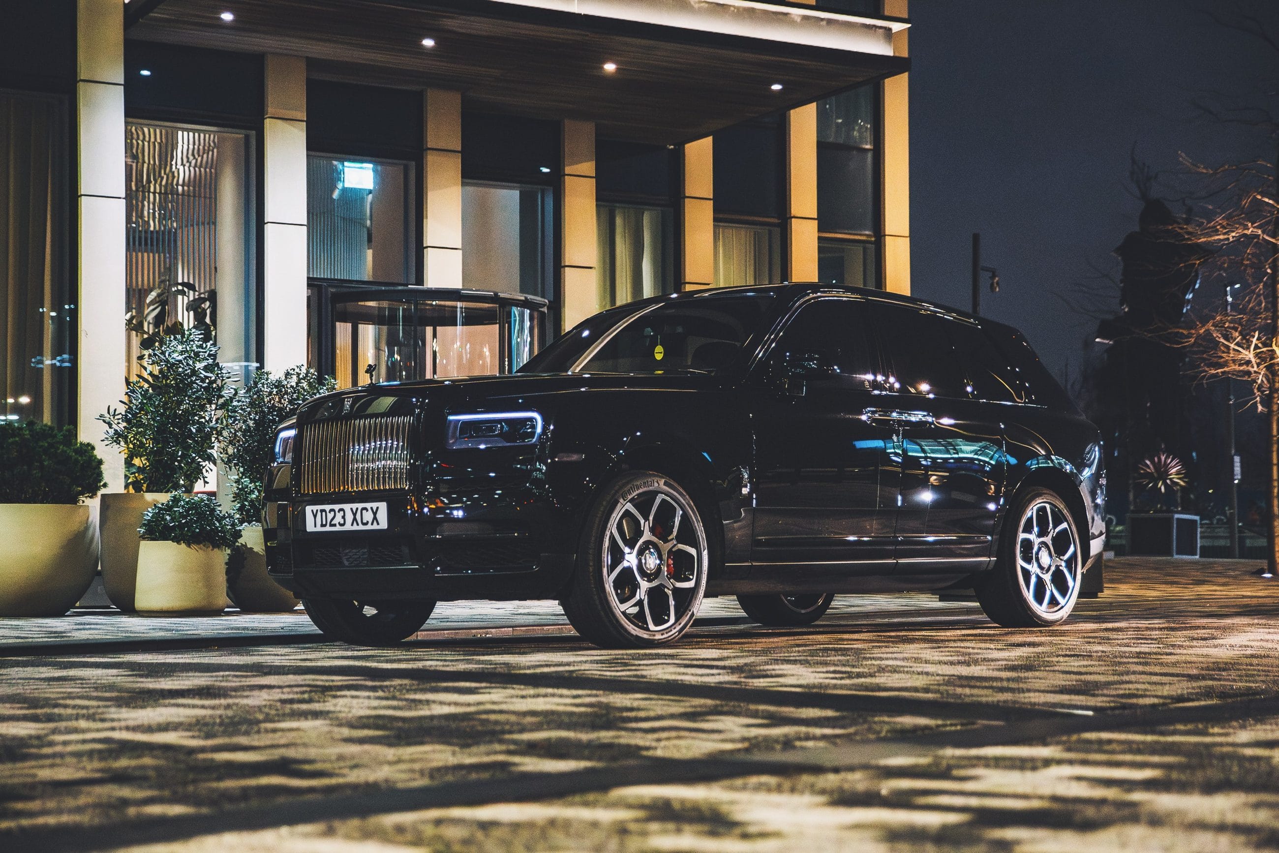 Rolls-Royce Cullinan waiting at a London hotel entrance at night